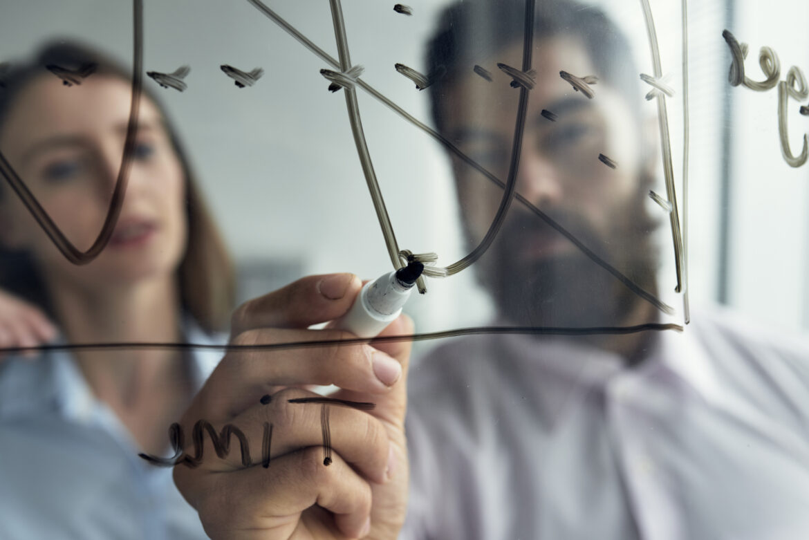 close-up-man-explaining-business-analytics-his-female-colleague-with-graph-whiteboard iniciativas de intraemprendimiento